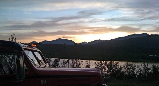 A red truck parked in front of a lake, So You Want My Job.