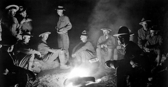 A group of men gathered around a campfire.