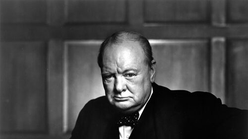 A black and white photo of a man in a suit, perfect for motivational posters inspired by Winston Churchill.