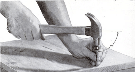 A person wielding a hammer skillfully on a piece of wood, showcasing excellent toolmanship.