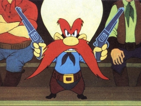 Yosemite Sam with long mustache holding guns.