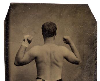 An old photograph of a man with his arms raised in celebration.