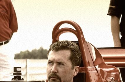 An SEO expert sitting in a red racing car.
