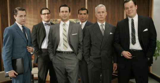 A group of Mad Men in suits posing for a picture, showcasing their manly haircuts.