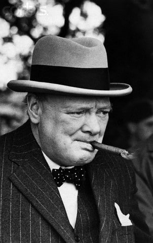 Winston Churchill with a hat smoking a cigar.