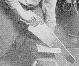 Man cutting the piece of wood with saw.
