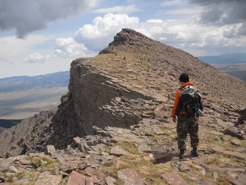 Man standing at mountain summit.