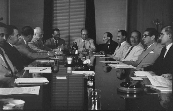 A group of men sitting around a table having a meeting.
