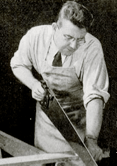 An old photo of a man demonstrating exquisite toolmanship with a handsaw.