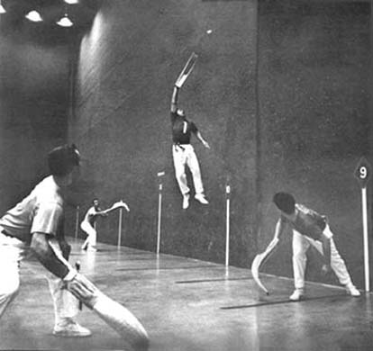 Vintage jai alai player jumping in air while playing.