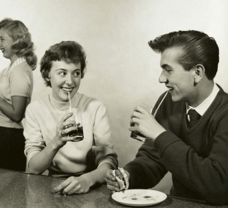 Vintage young couple smiling and looking at each other on their date.