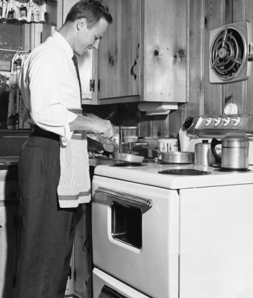 A man in an apron is preparing food in a kitchen, aiming to Impress a Date with 3 Great Meals.