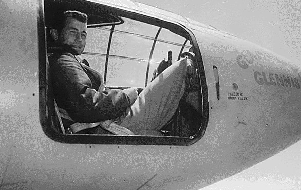 Chuck Yeager sitting in the nose of airplane.