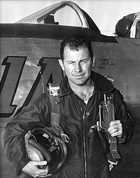 Vintage Chuck Yeager standing in front of airplane.