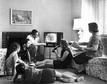 Vintage family watching tv in living room.