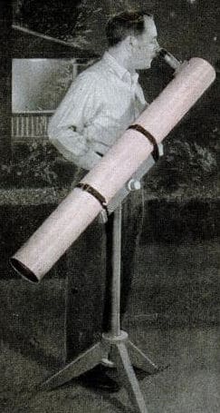 Vintage man looking through large backyard telescope.