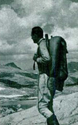 Vintage man wearing backpacking and standing on mountains.