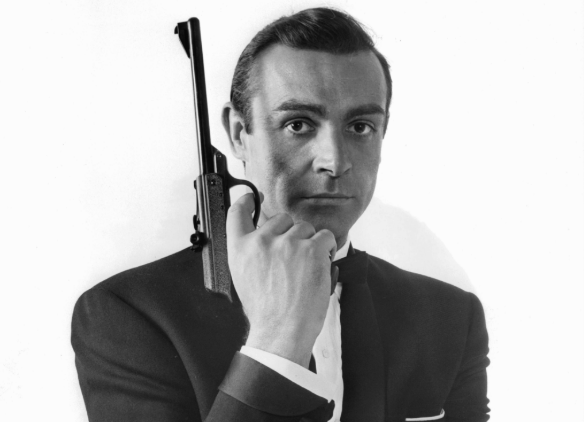 A man holding a gun in a black and white photo.