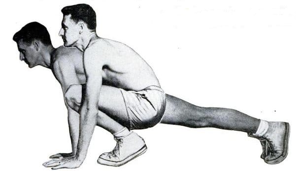 A man and a woman engaging in exercise by doing squats.