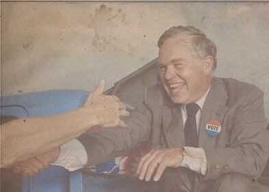 A man is shaking hands with a man in a suit during a local office political campaign.