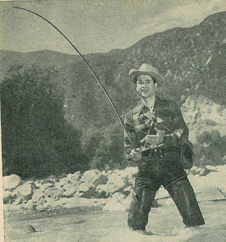 Vintage man fishing in river near mountains.