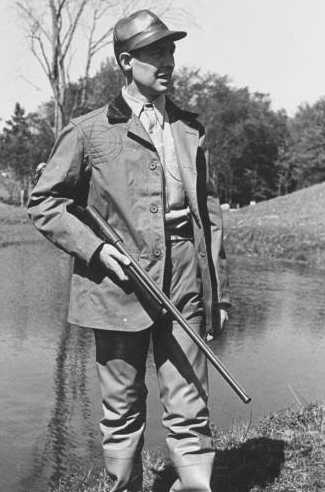 Vintage man holding gun near the pond.