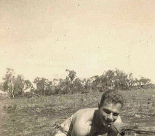 Building resiliency, a man lifts a log in a field.