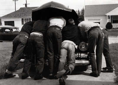 Vintage men working on car engine.