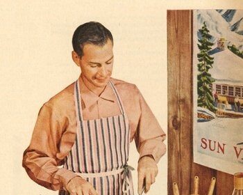 A man in an apron is preparing food from a Valentine's Day menu on a table.
