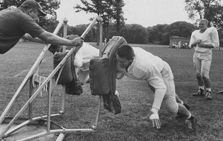 A black and white photo of a group of football players showcasing their hustle.