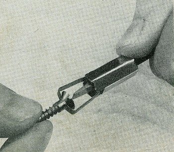 Vintage man holding a screw with screwdriver.