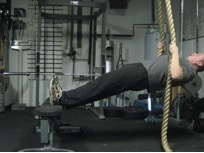 Man doing exercise of rope holding at gym.