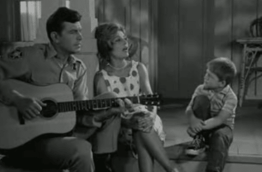 Andy Griffith playing guitar with family.