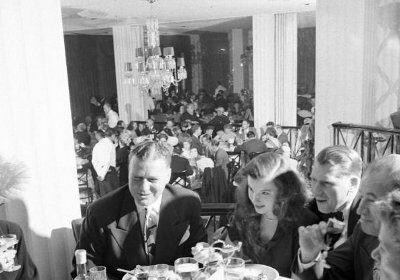 A group of people practicing dining etiquette and table manners gathered around a table.