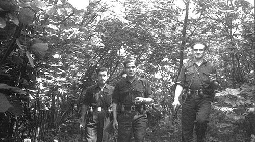 Three men in uniform showcasing their resiliency as they confidently navigate through the woods, forming a strong building of unity with their signature strengths.