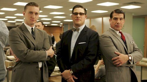 Mad Men's Rich Sommer, along with two other men in suits, standing in an office.