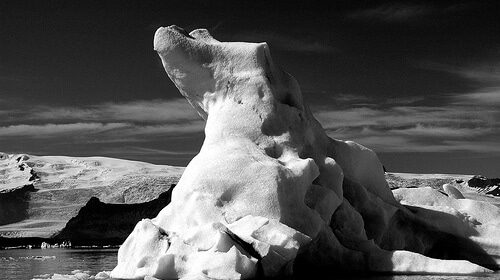 An iceberg in the water, showcasing its resiliency against natural forces.