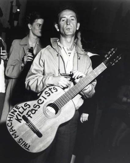 Woody Guthrie capture a moment with guitar. 