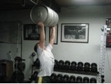 Man doing exercise of keg holding at gym.