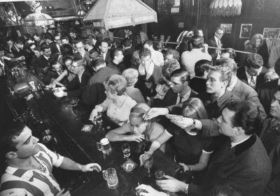 A busy bar with people enjoying their drinks.