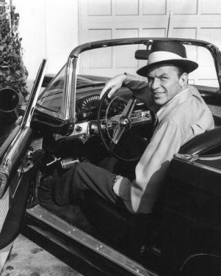 Frank sinatra in convertible wearing hat.