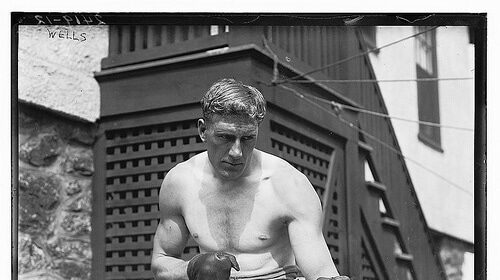 A black and white photo of a man in boxing gear, demonstrating the Boxing Basics.