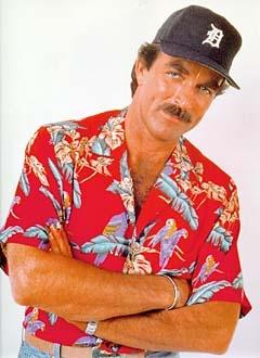 Tom Selleck wearing cap and red pattern shirt in a shot.