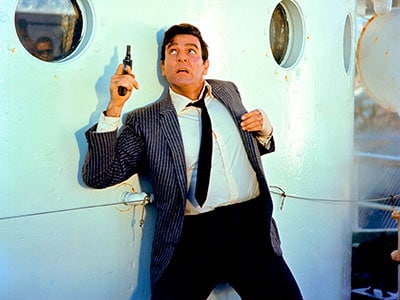 A man holding a pistol in Joe mannix classic cop detective tv show.
