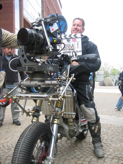 Greg Tracy stuntman sitting on camera bike.