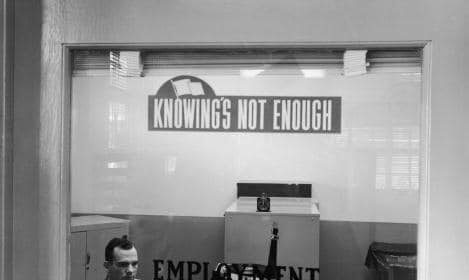 A man in a suit prepares for a behavioral job interview at an office desk.