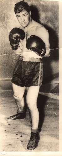 Rocky Marciano wearing boxing gloves and shorts.