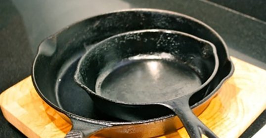 One cast iron skillet on top of a wooden cutting board.