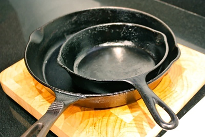 One cast iron skillet on top of a wooden cutting board.