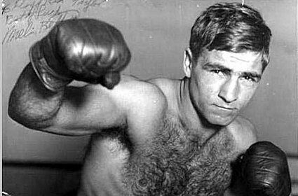 A boxing aficionado captured a striking black and white photo, highlighting the raw intensity of a man in boxing gloves as he showcases impeccable punching combinations. This captivating image showcases the essence of boxing,